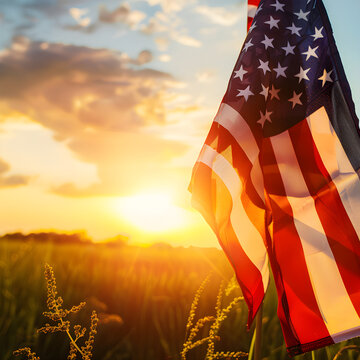 American flag waving in the wind with a golden field in the background at sunset