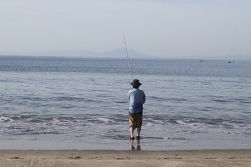海で釣りをする女性