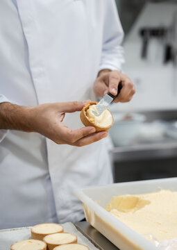 Pastry chef spreading cream on dessert base