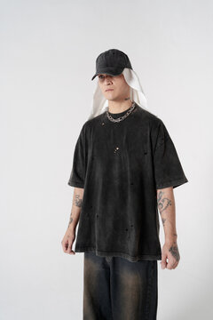 Stylish young man standing. Wearing casual clothes and baseball cap