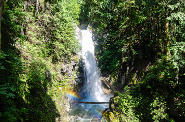 Fototapeta premium Cascade Falls located Northeast of Mission, BC, Canada. The sunlight falling on the droplets forms a rainbow.