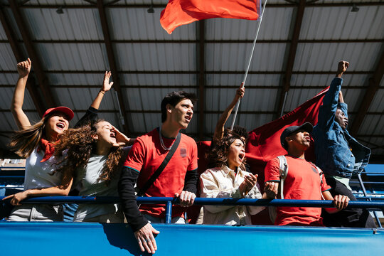 Enthusiastic fans cheering at a game in stadium