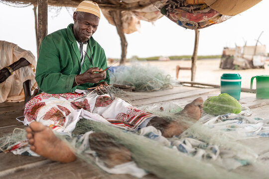 Fisherman repairing nets in senegal