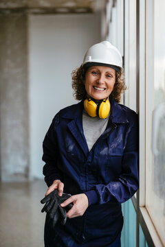 Confident female construction worker with protective gear