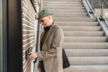 Middle age man opening entrance door with digital key