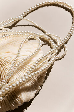sea coral shells and pearl necklace on a light background.