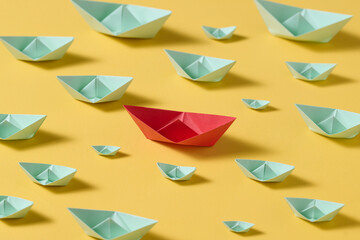 Leadership concept using red paper ship among with the white ones