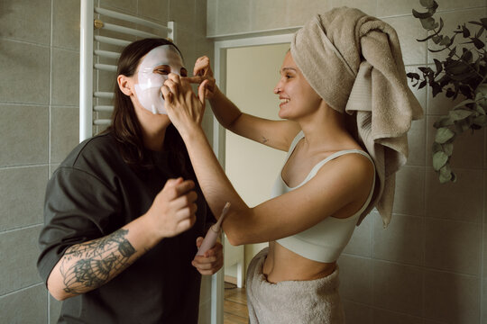 Woman helping friend face mask