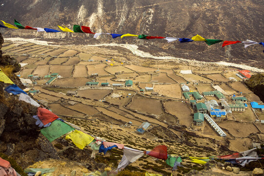 Colorful prayer flags over Himalayan high altitude village and fields