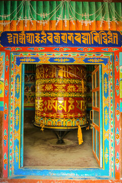 Large colorful prayer wheel inside a Buddhist temple
