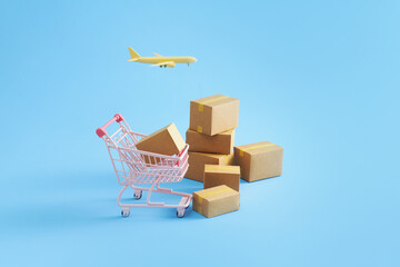 Trolley with carton and airplane. Shopping and shipping worldwide