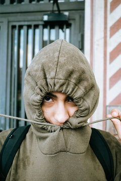 Hooded Person Pulling Drawstring Tight