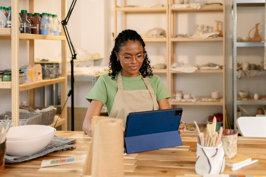 Creative Woman Planning on Digital Tablet in Ceramic Studio