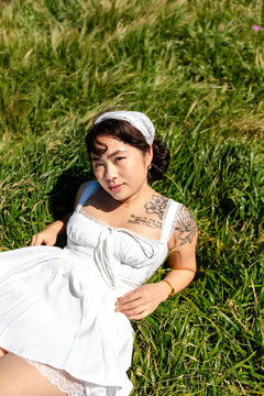 Portrait of alluring woman relaxing on grass 
