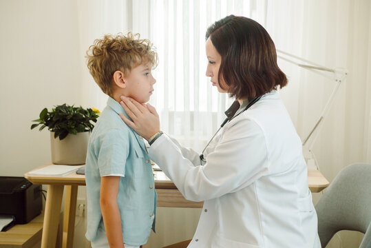 Pediatrician checks the condition of  young boy's lymph nodes