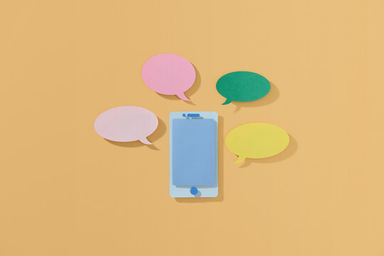 Paper-cut smartphone icon with a speech bubbles