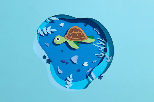 Paper-cut marine life with turtle and fish in the ocean background