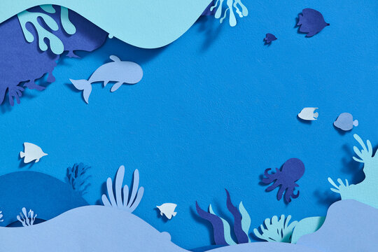 Paper underwater sea cave with fishes, coral reef in the seabed