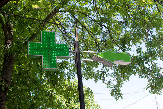 Green pharmacy sign against green leaves