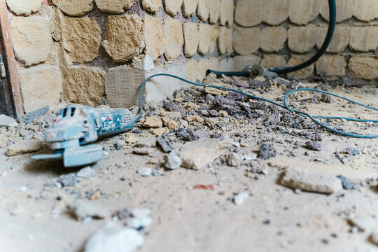 Electric disc cutter lying on floor of shabby building