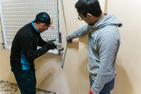 Repairers installing curtain on wall