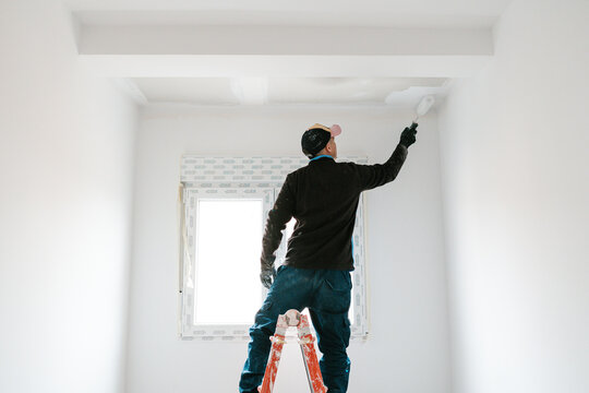 Unrecognizable painter working on ceiling