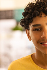 Smiling teenage boy in high school, wearing yellow shirt, close-up portrait, copy space