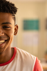 Smiling teenage boy in high school, wearing casual shirt, enjoying classroom environment, copy space