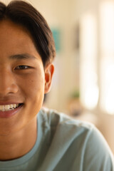 Smiling teenage boy in high school, natural light highlighting close-up portrait, copy space