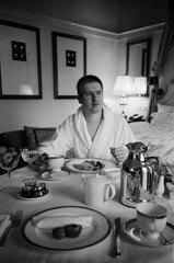 A man is enjoying a luxurious breakfast in an elegant hotel room