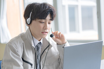 インカムをした若い作業服男性