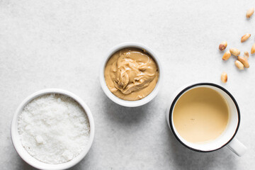 Overhead view of mise en place of ingredients for making peanut butter fudge, top view of peanut butter sugar and milk on a marble countertop, process of making peanut butter fudge