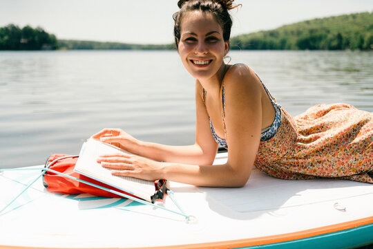 young woman relaxing and reading. on paddle board 