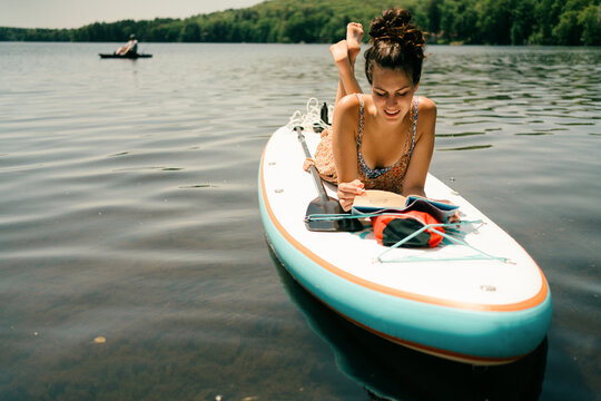 young woman relaxing and reading. on paddle board 