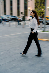 Confident woman striding through city in smart business attire