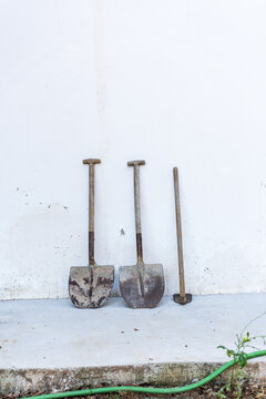 Shovels and a Sledgehammer Leaning Against a Wall
