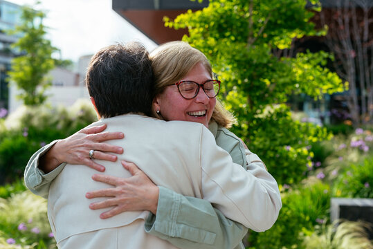 Happy senior woman hugging in the street