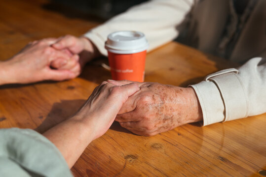 Senior couple holding hands in a coffee shop