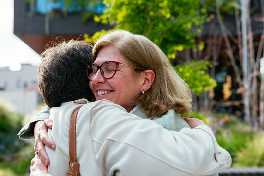 Senior woman hugging in the street