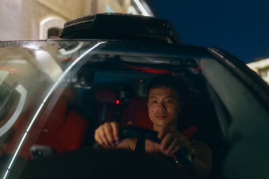 Emotional man in car on rainy night.