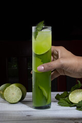 green cocktail with herbs and lemons