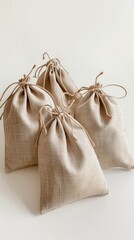 Four Burlap Drawstring Bags on a White Background, Rustic Eco-friendly Packaging Concept