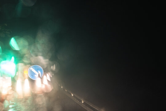 Roadworks at night, blurred by raindrops