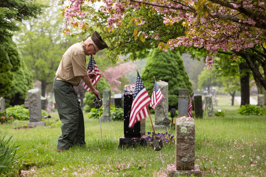Senior military War Veteran American Flag at grave cemetary