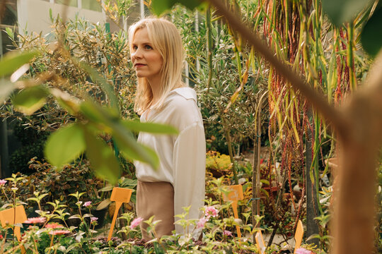 Blond woman in a greenhouse during golden hour