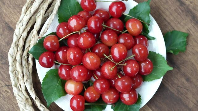 Top view Rotate Red Cherry fruit on wooden background, Japanese Red highest variety of Yamagata cherries on white table.
