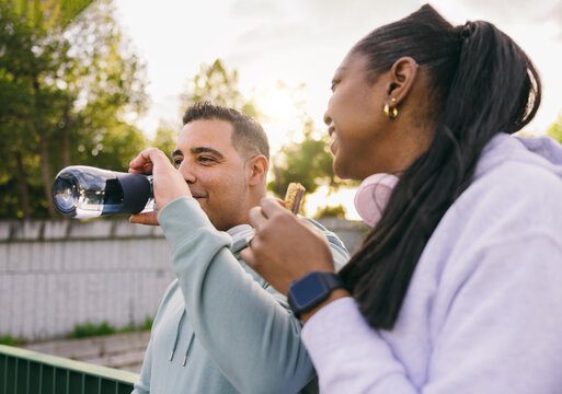 Active Dominican couple sharing a snack during a break outdoors