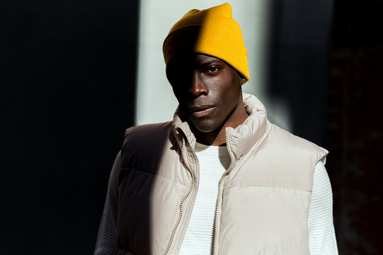 Stylish young man in yellow beanie and winter jacket