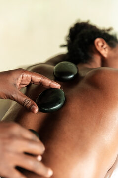Woman receives healing hot stone massage on her back
