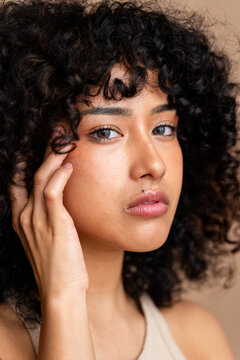 Portrait of a curly-haired young woman gazing gently